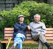 IKOR two Asian seniors sitting on bench