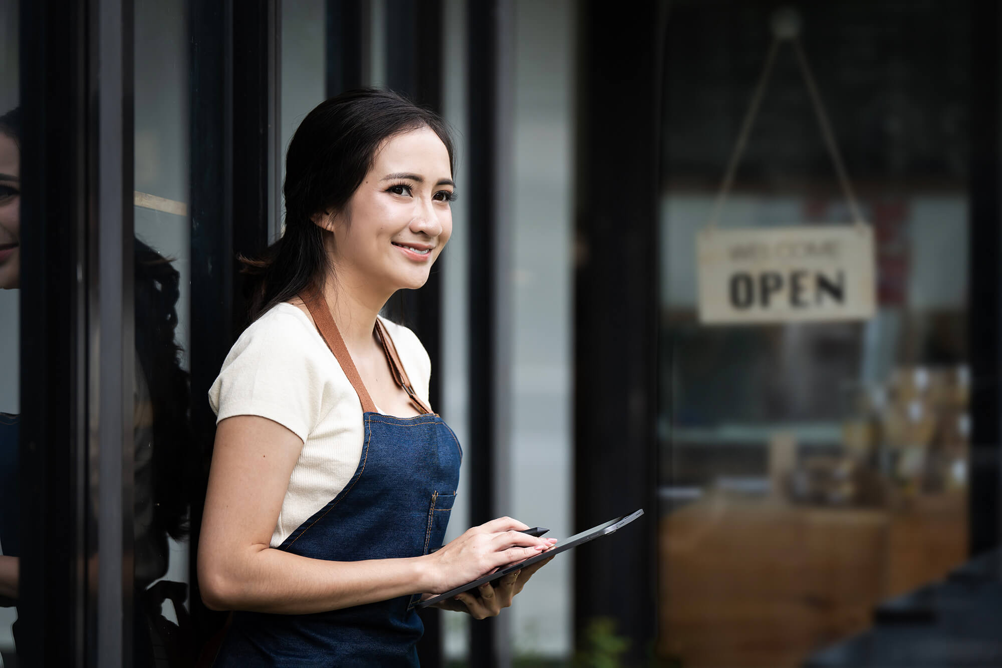 Woman wearing apron outside of a franchise