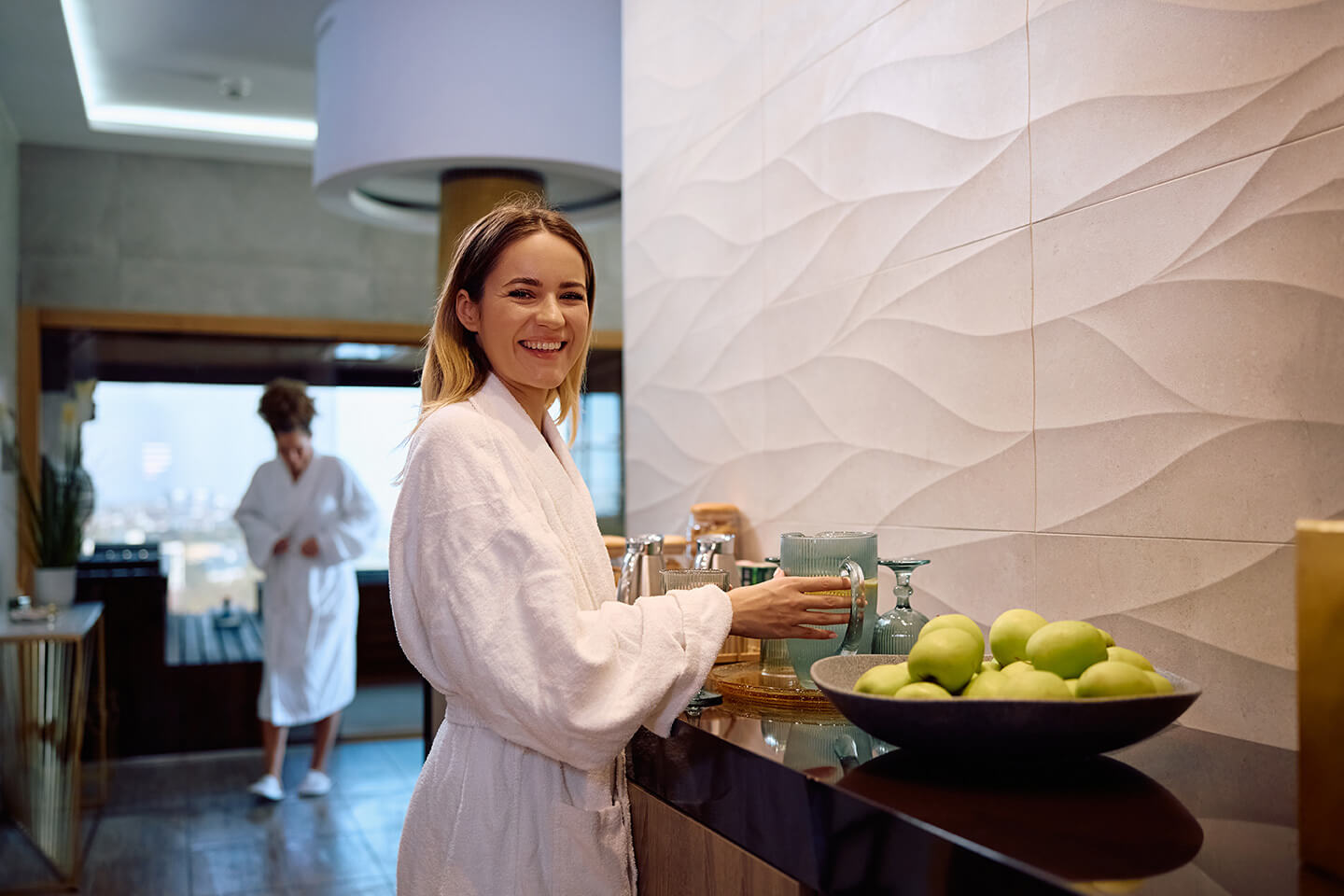 Happy woman drinking fresh lemon juice at the spa